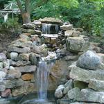 Multi-level waterfall features a Koi pond below.